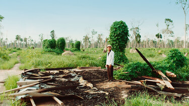 Szenenbild: Kleinbauer auf den Resten seiner zerstörten Hütte
