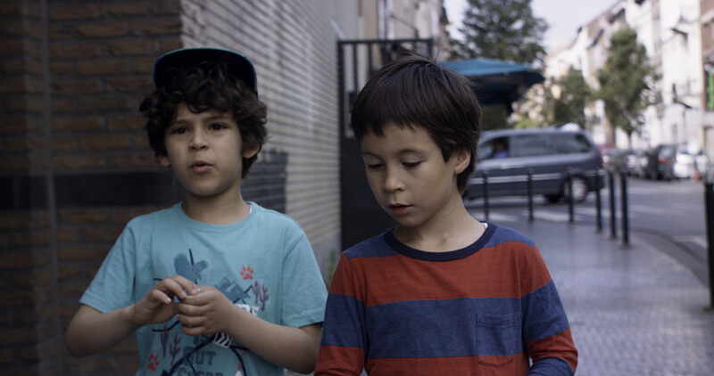 Filmstill "Die Götter von Molenbeek", Amine und Aatos laufen durch die Straße und unterhalten sich