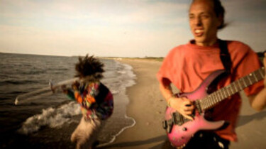 Szenenbild: Luis und Elias, die Straßenmusiker, am Strand