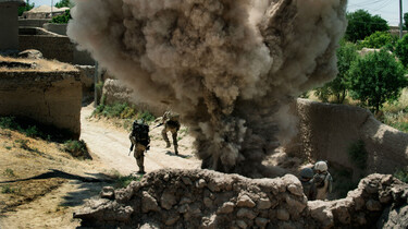 Szenenbild: Zwei Soldaten der Bundeswehr laufen vor einer Explosion davon