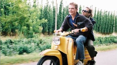 Szenenbild: Annika und ein junger Mann auf einem gelben Motorroller