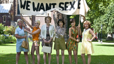 Szenenbild: Sechs Frauen die auf einer Wiese stehen und ein Plakat mit der Aufschrift "We want Sex hochhalten"
