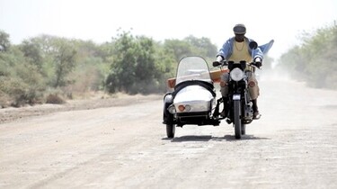 Szenenbild: Ein Mann auf einem Motorrad mit einem "Beigestell"