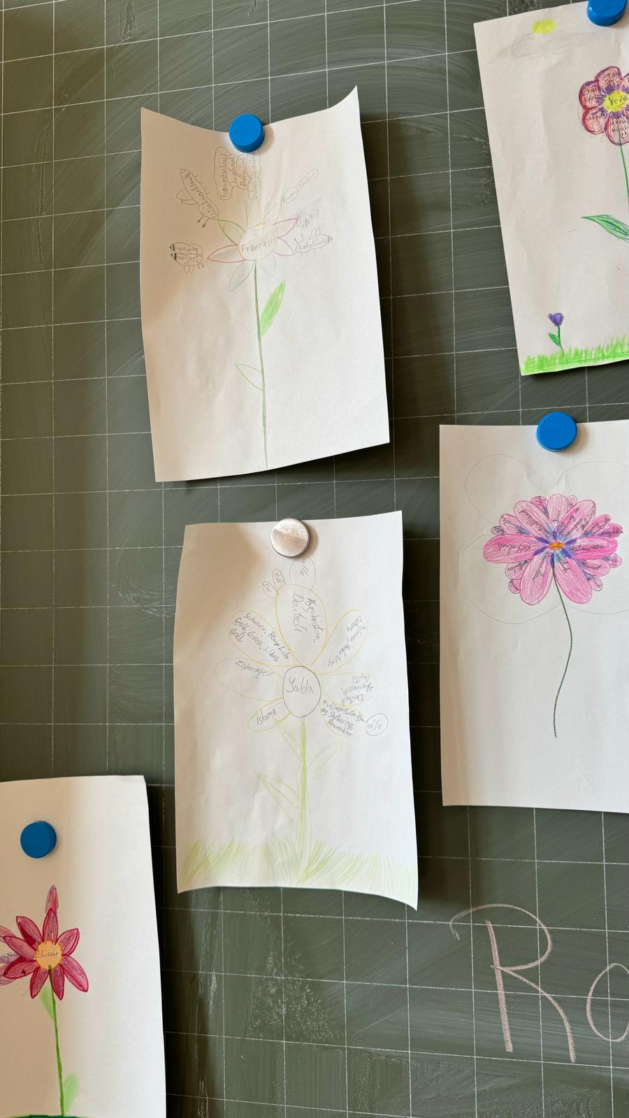 Bilder mit ausgefüllten Blumen an der Tafel